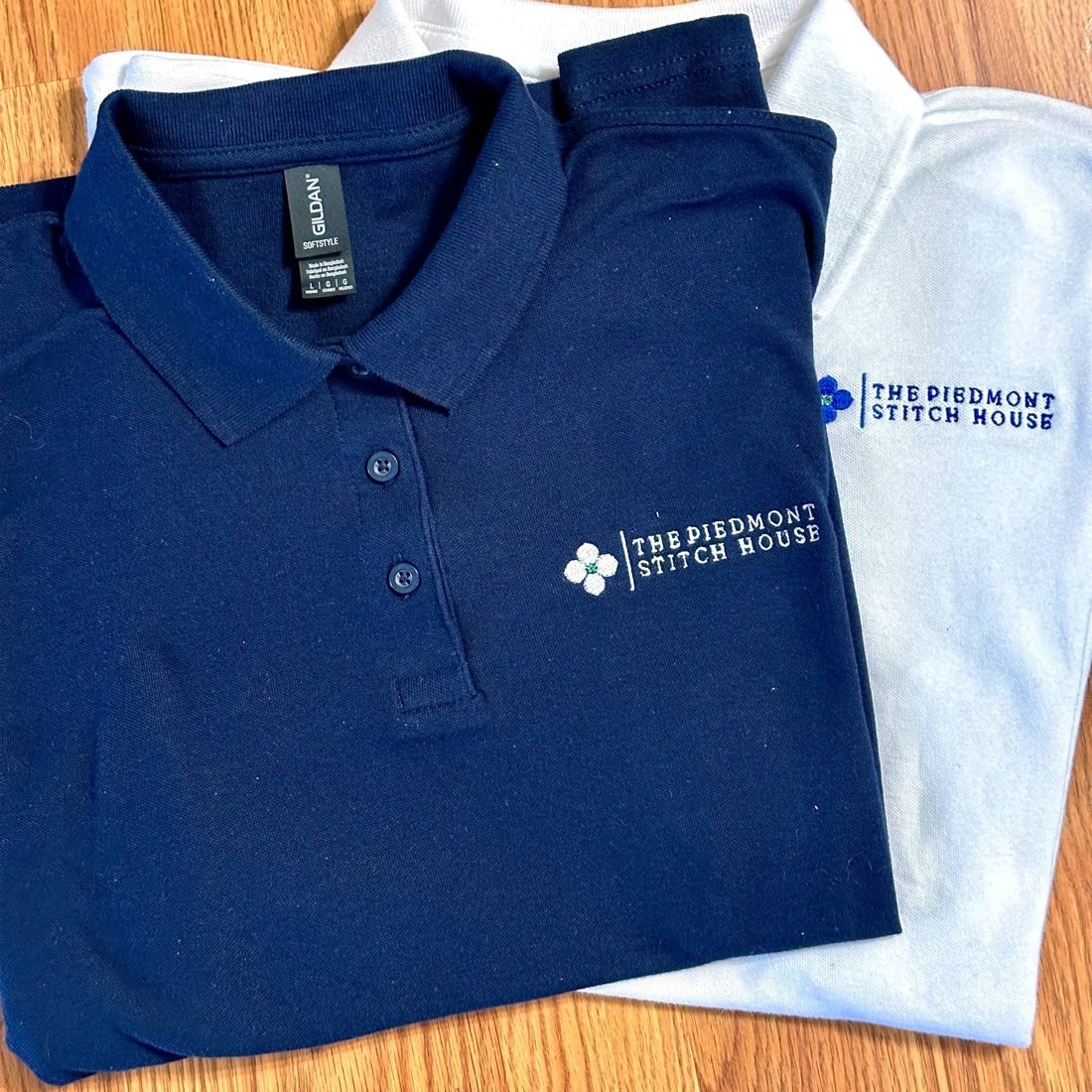 A close-up of an embroidered left-chest logo on a navy polo